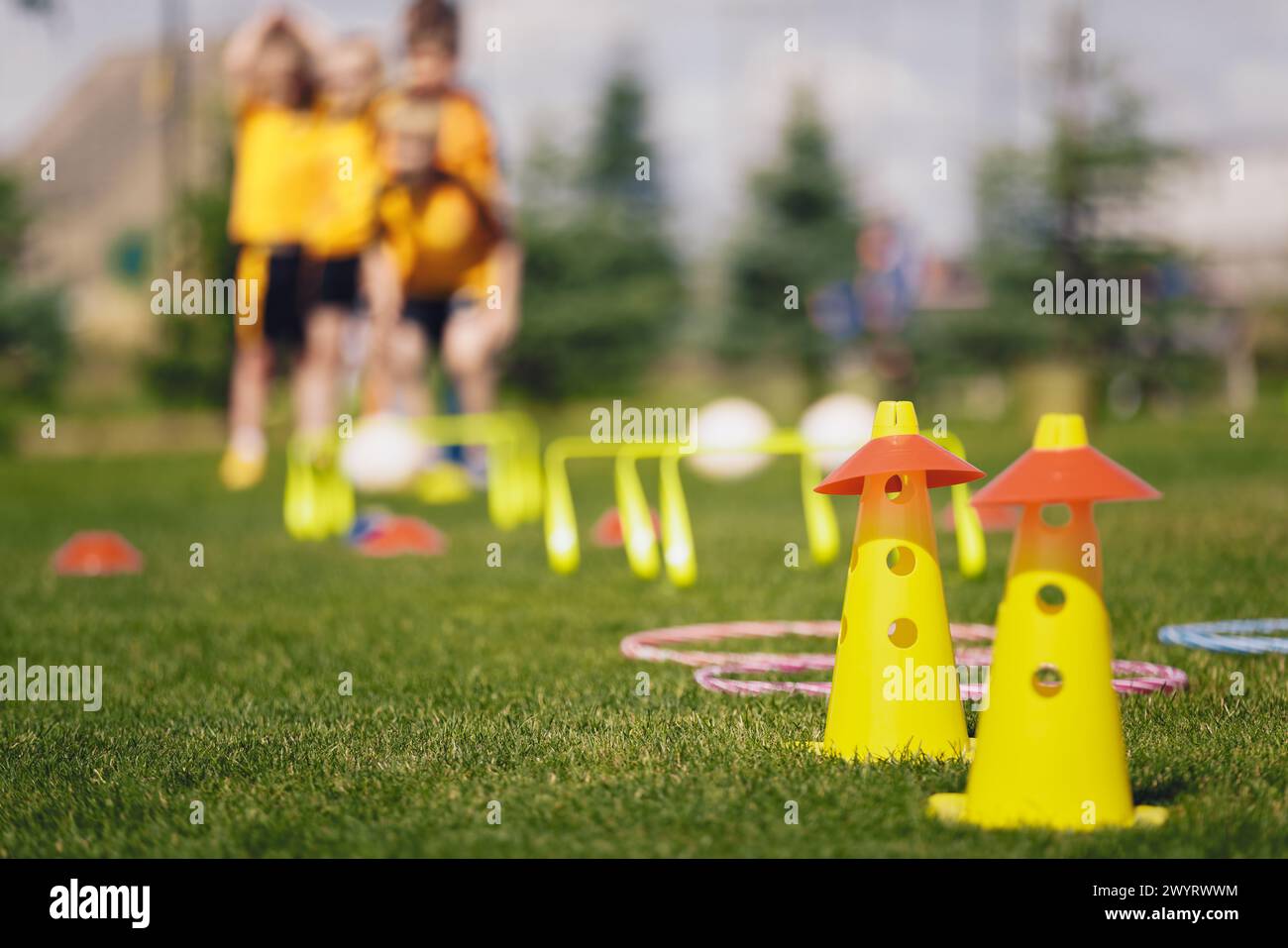Sports traiing camp equipment for chldren. Young football players at summer practice camp. Kids at training obstacles course Stock Photo