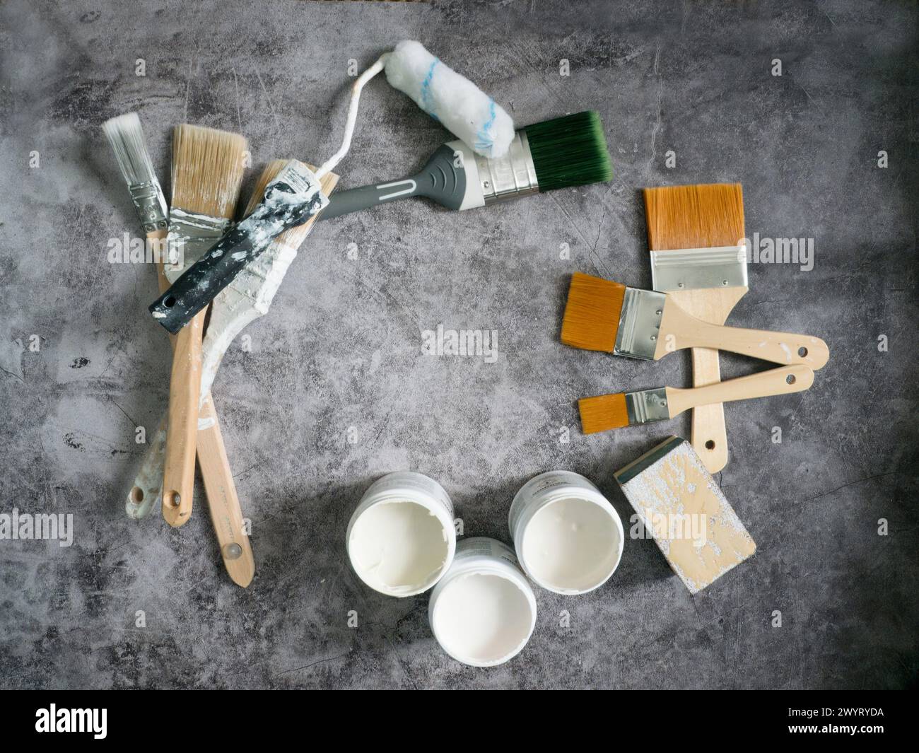 Various paint brushes, roller and paint samples on stone floor background Stock Photo