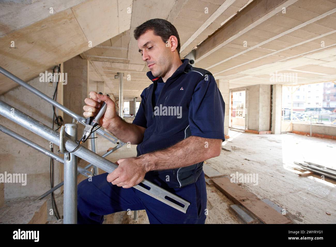 Worker using pliers, new homes under construction, construction site. Stock Photo