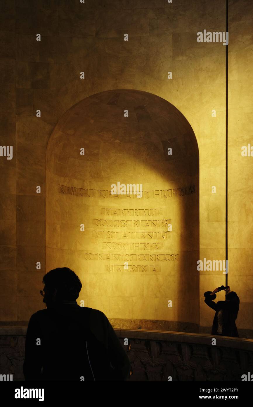 Silhouettes of two visitors, golden light, an arched niche in the Anzac
