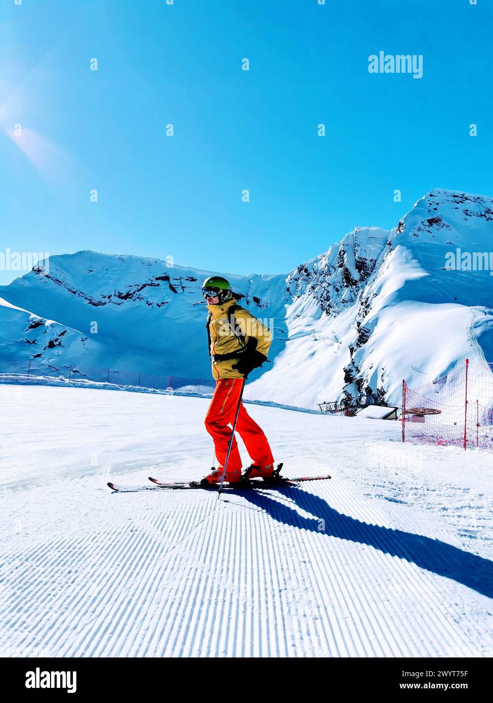 A skier in striking red pants surveys the snow-covered slopes, ready to ...
