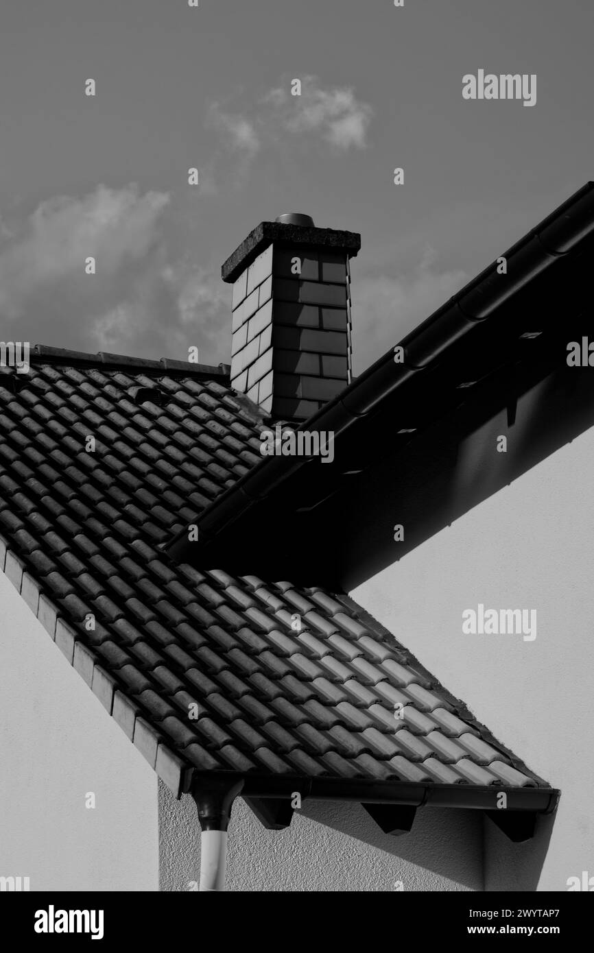 Details of roofs and a chimney in bright sunlight with formal symmetry and appealing areas of lights and shadows (black & white) Stock Photo