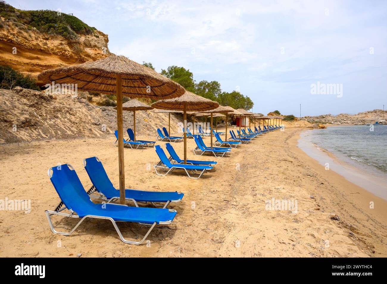 Sun loungers on sandy Limnionas beach. Kos island, Dodecanese, Greece Stock Photo