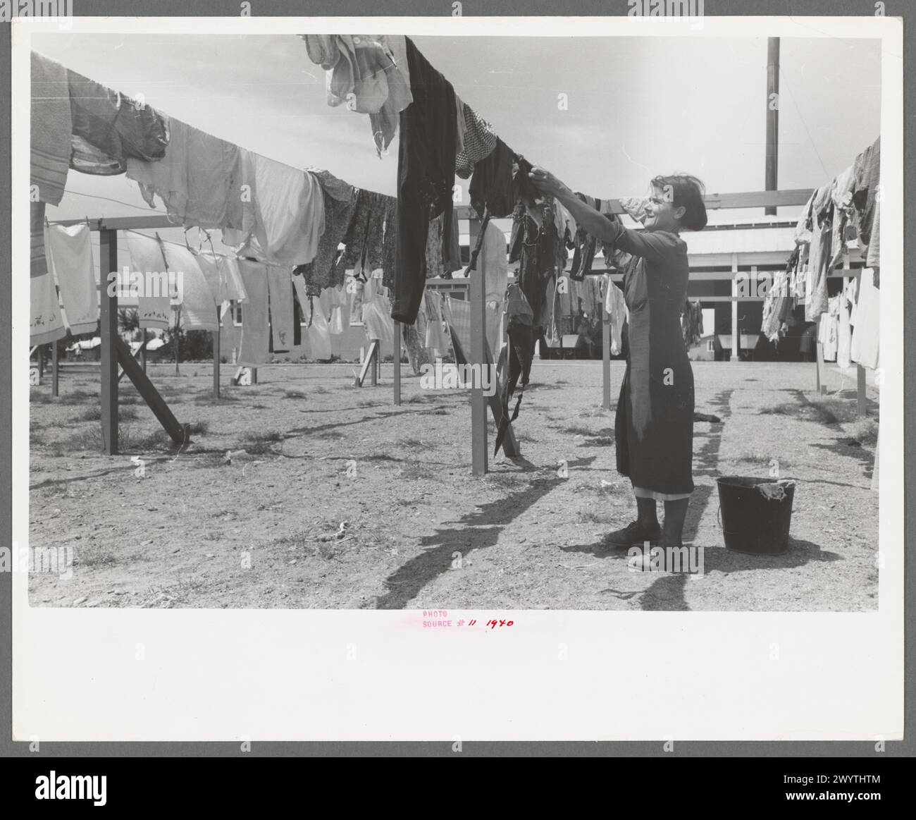 Wife of migratory worker hanging up laundry at the Agua Fria Migratory Labor Camp, Arizona 1940 Stock Photo