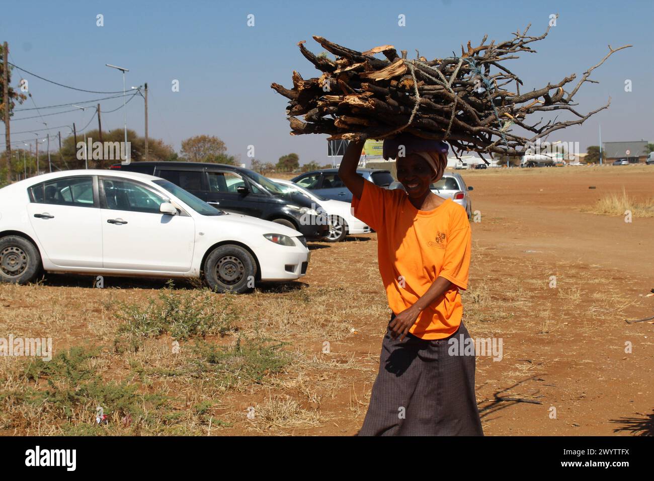 Francistown, Botswana. 23rd July, 2023. Tiny Moloi carries firewood on her head in Francistown, Botswana, July 23, 2023. TO GO WITH 'Feature: Botswana's forests go up in smoke to plug electricity gap' Credit: Shingirai Madondo/Xinhua/Alamy Live News Stock Photo