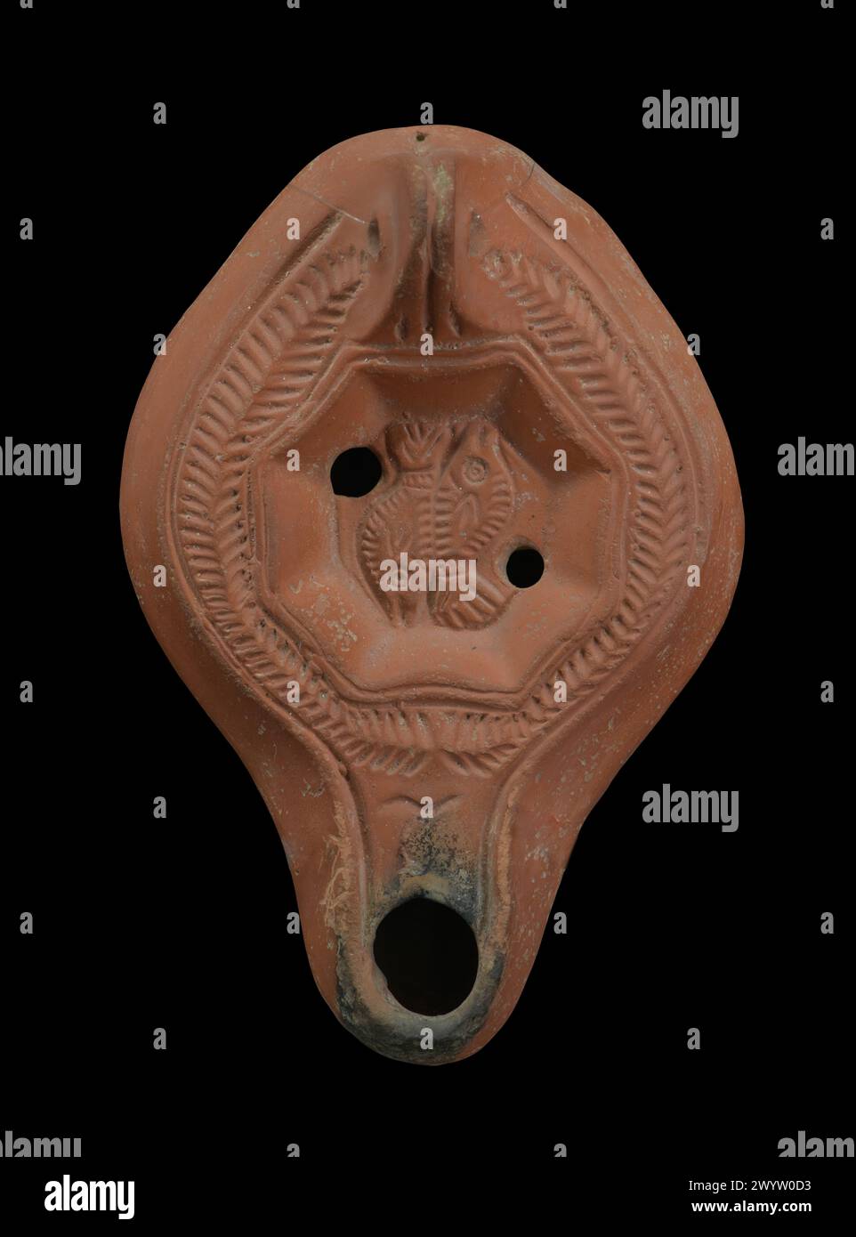 Ancient Roman oil lamp with the zodiac sign of the pisces isolated Stock Photo