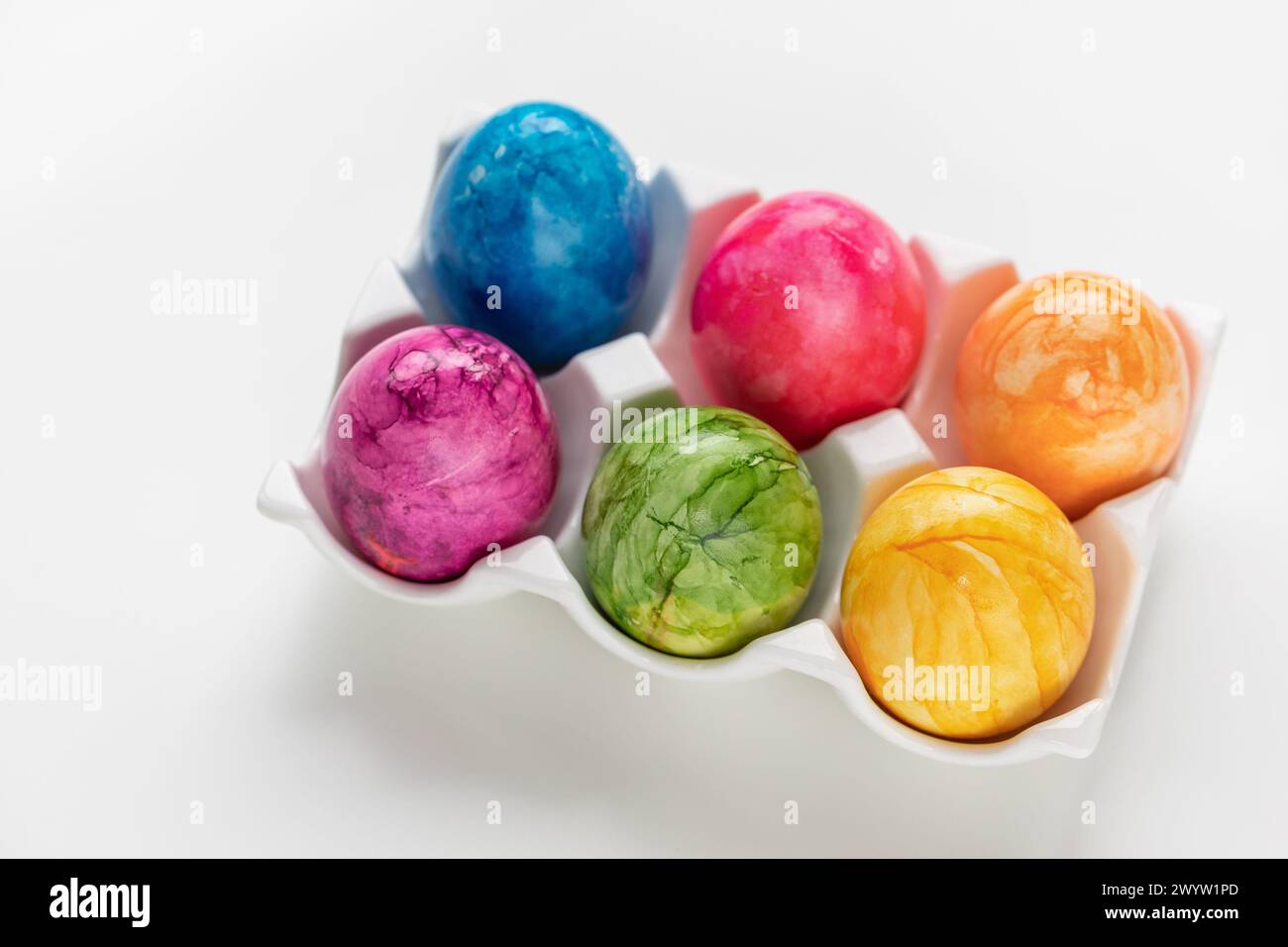 Assorted vibrant Easter eggs on white background, festive decoration Stock Photo