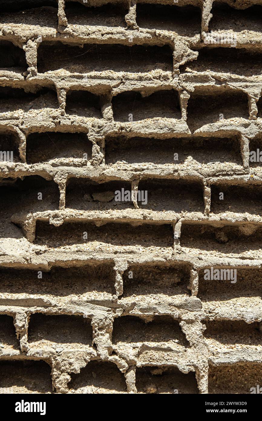 The cemented holes where the bricks have been weathered away in a wall in an abandoned mine house in Bogenfels, Namibia. Stock Photo