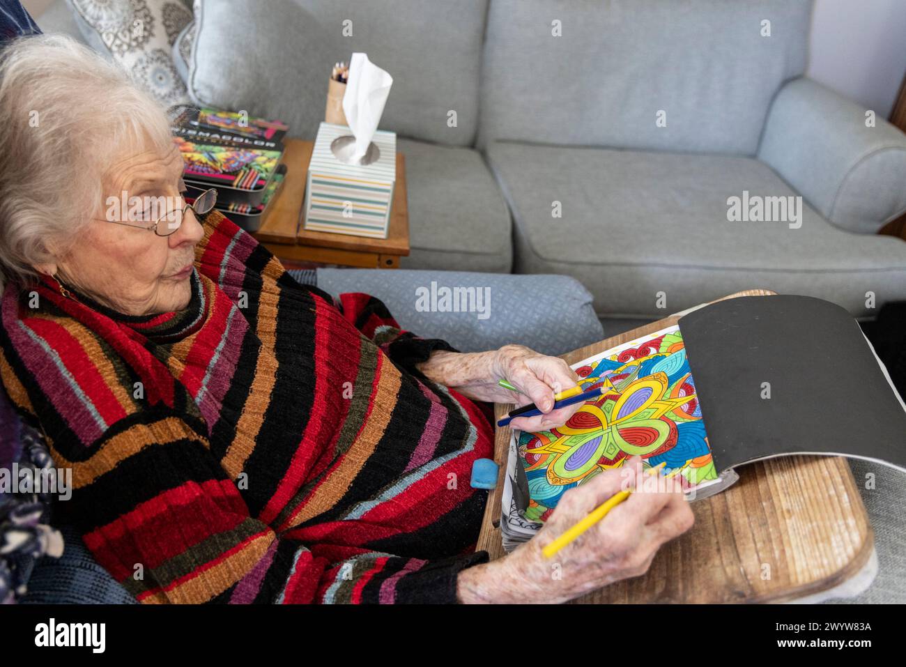 Elderly woman (89 years old)  with adult coloring book to reduce anxiety and improve brain function, Dover, Delaware Stock Photo