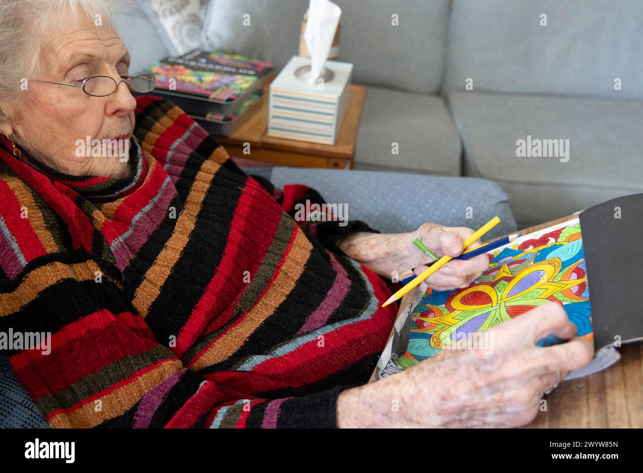 Elderly woman (89 years old)  with adult coloring book to reduce anxiety and improve brain function, Dover, Delaware Stock Photo