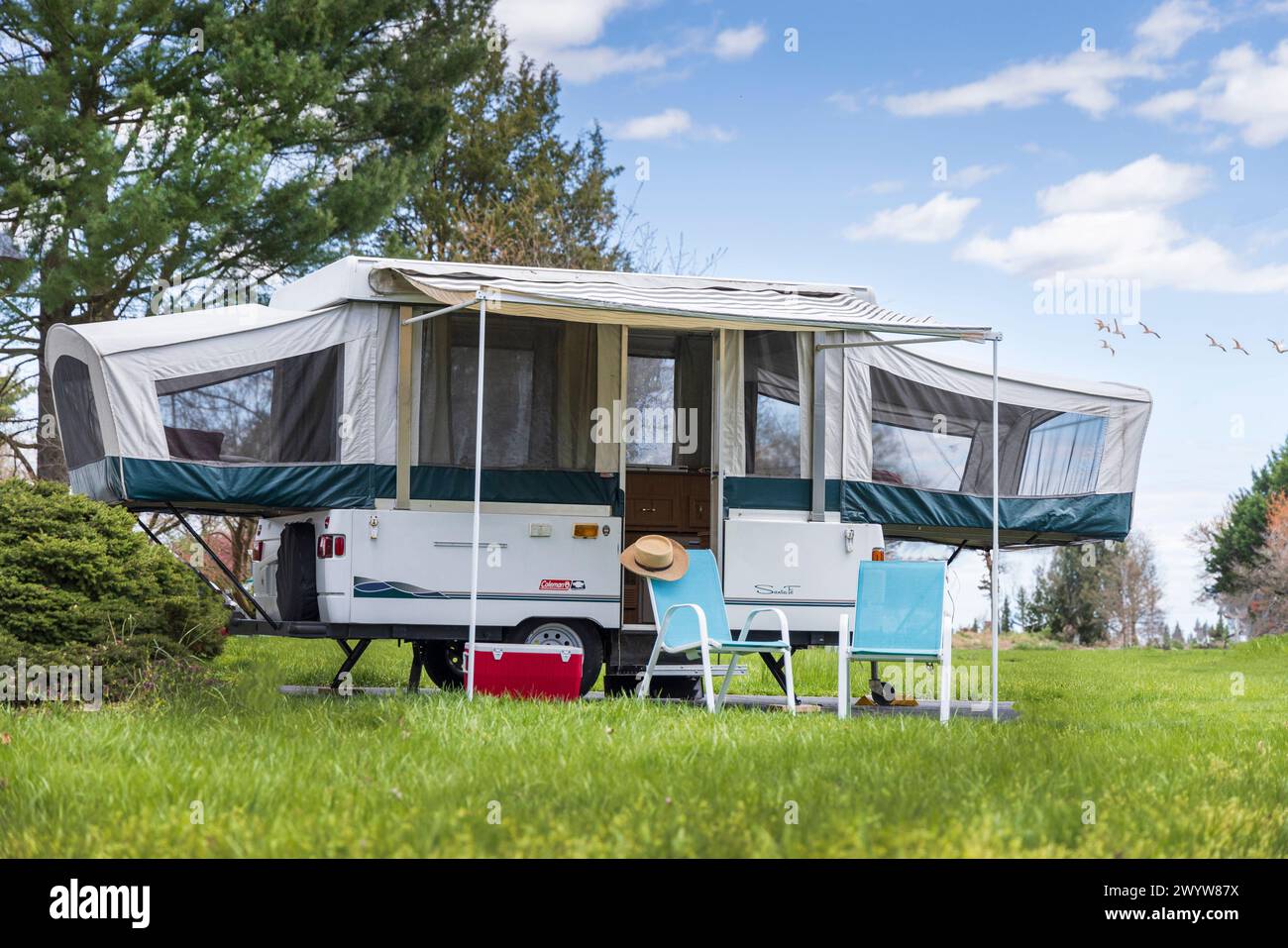 Pop up camper with awning and two chairs in country, Delaware, USA Stock Photo