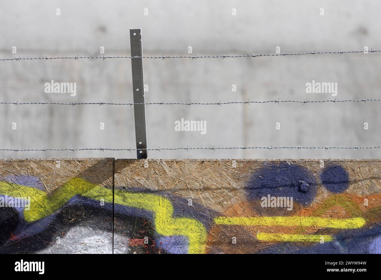 Stacheldraht auf einer mit Graffiti bespruehten Absperrung einer Baustelle in Berlin, 08.04.2024. Berlin Deutschland *** Barbed wire on a graffiti-cov Stock Photo