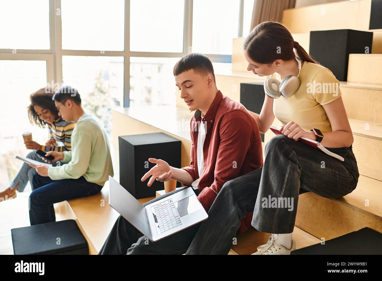 A multicultural group of students relaxes and converses while seated ...