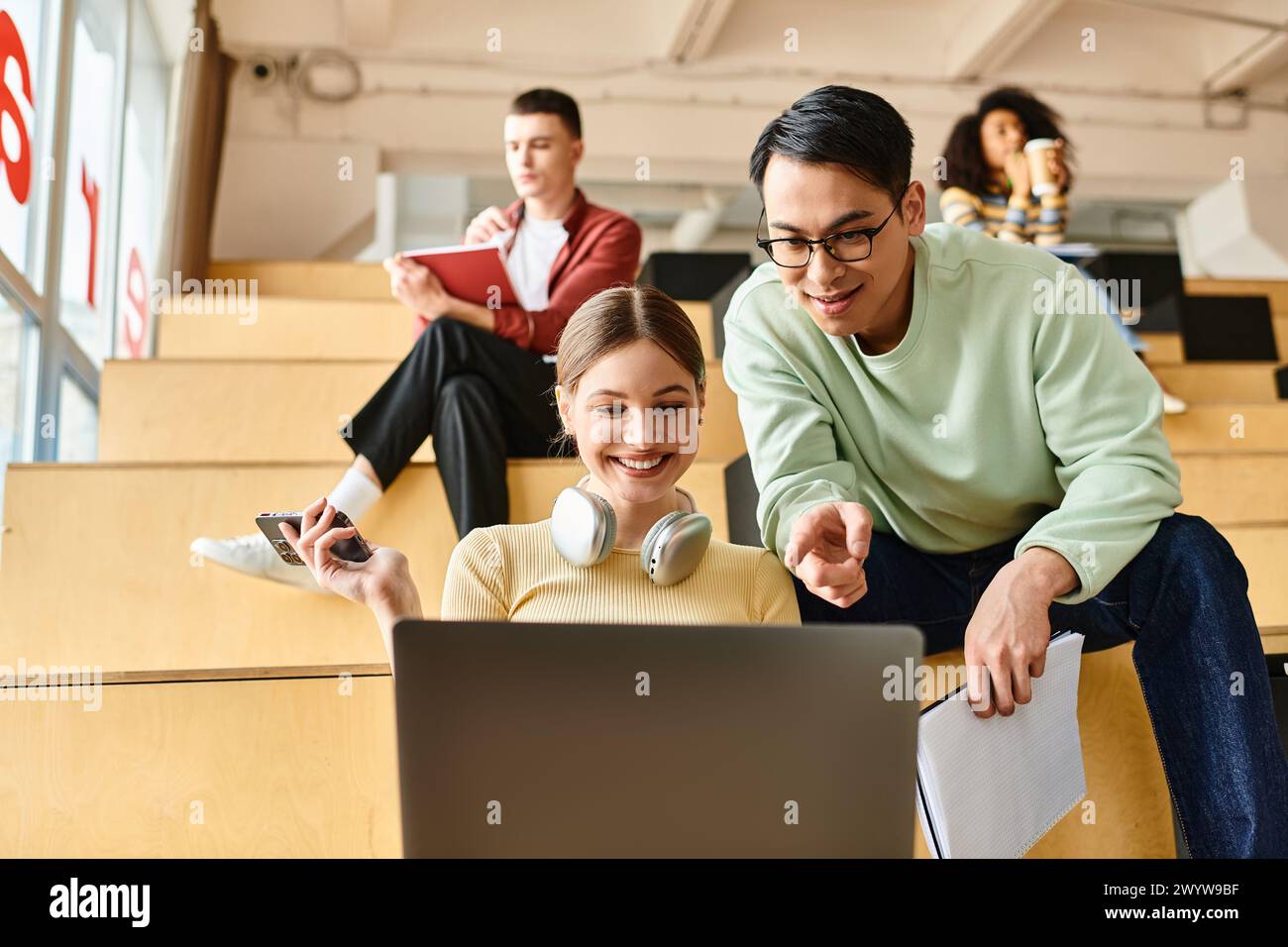 A multicultural woman deeply focused, sits in front of a laptop computer, engaging in online education or work Stock Photo