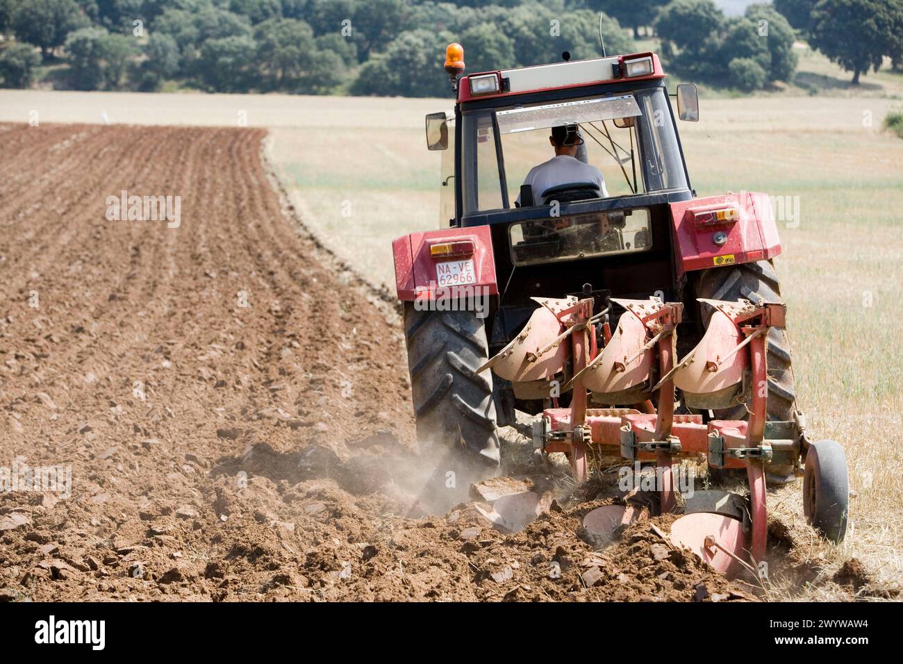 Agricultural machinery. Tractor ploughing the land. Mouldboard plough. Harvesting of cereals, Oco (near Estella), Navarre, Spain. Stock Photo