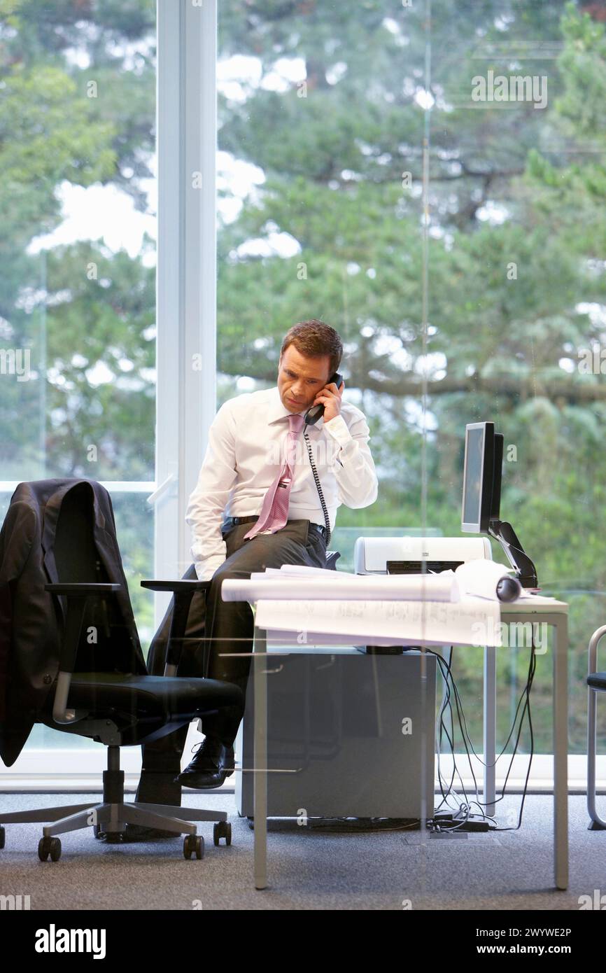 Architect with blueprints in office. Stock Photo