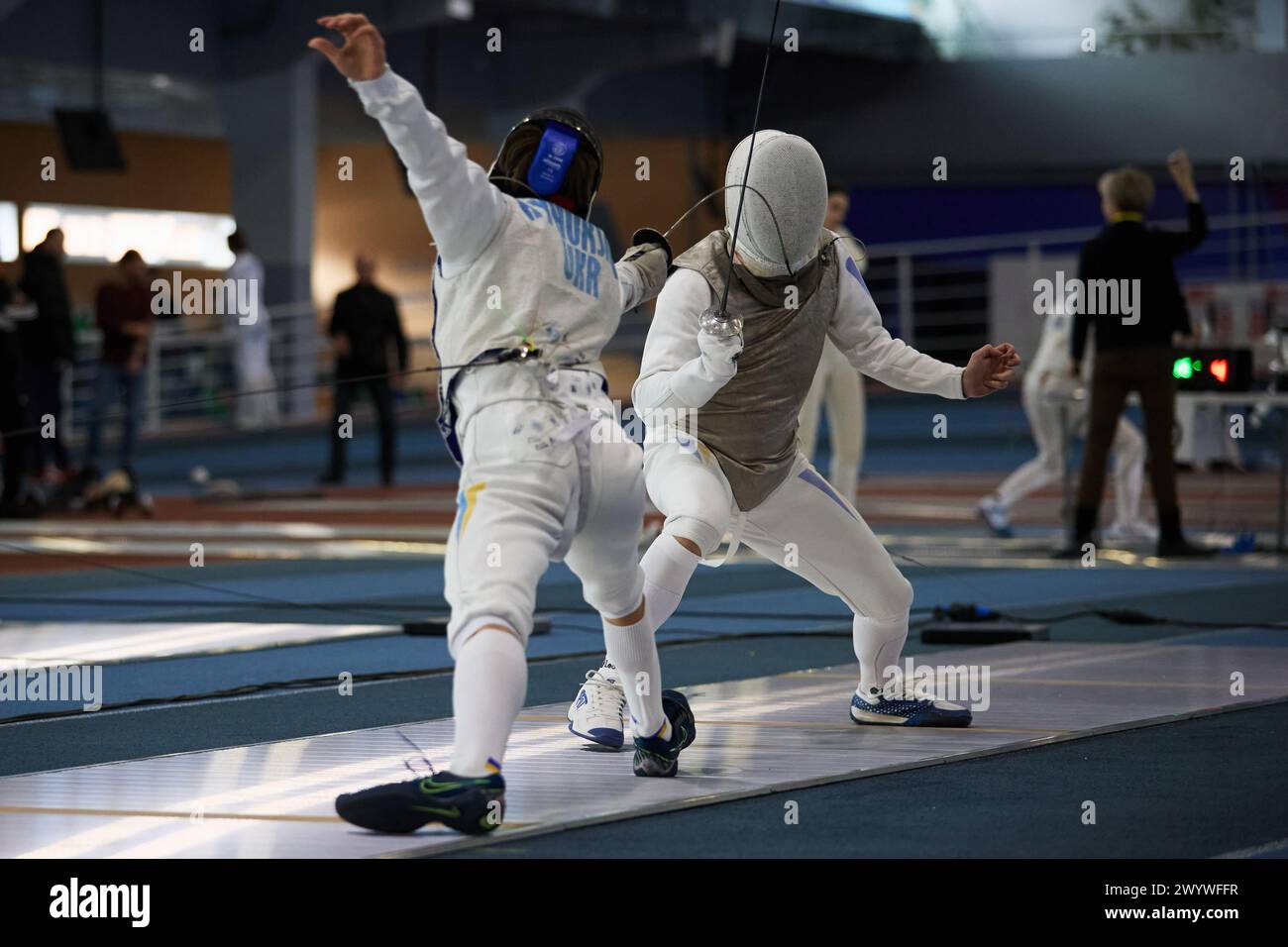 Fencers wearing protective lame jackets and masks fight during the National Fencing Championship