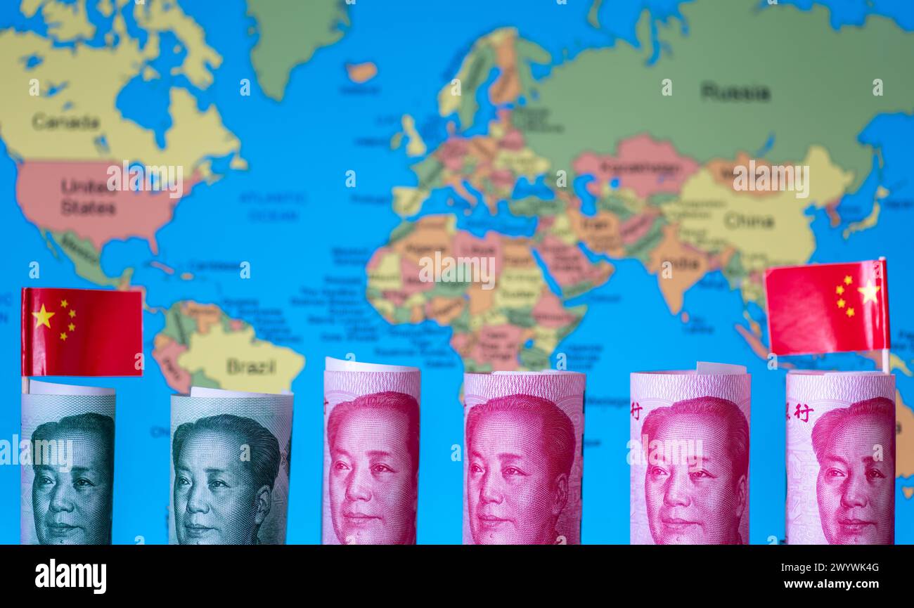 A Chinese world wide investment concept, Belt and Road Initiative, with rolls of Chinese yuan and national flags over a map of the world. Stock Photo