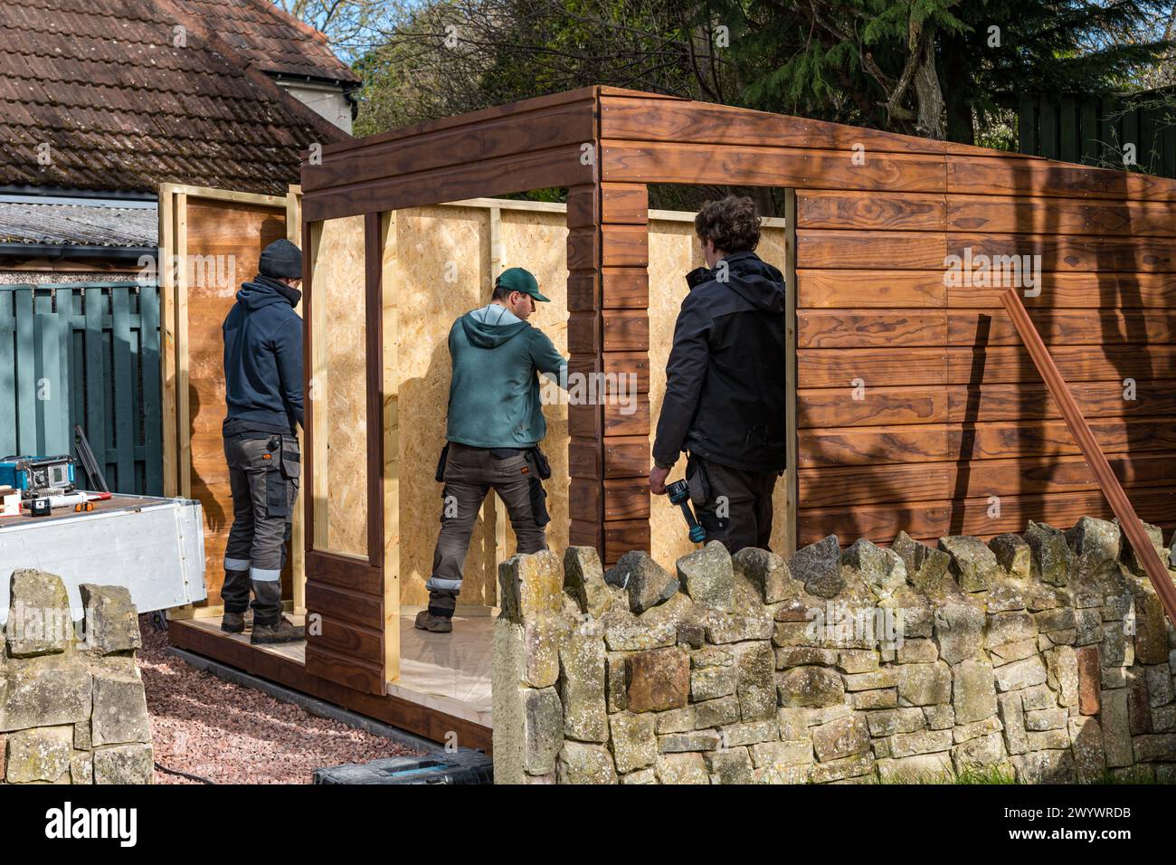 Joiners and workmen erecting the walls of a shed and garden room, Scotland, UK Stock Photo