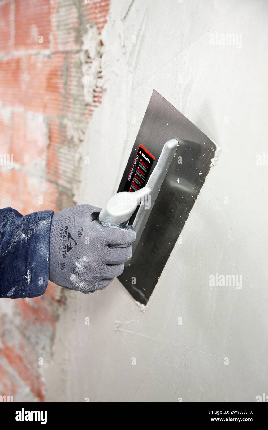 Rendering a brick wall using trowel, new homes under construction, construction site. Stock Photo