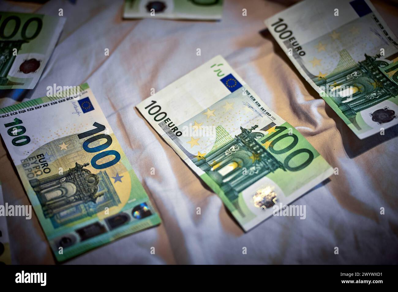 31 March 2024: Symbolic image of counterfeit money, euro cash banknotes scattered on a bed sheet *** Symbolbild Falschgeld, Euro Bargeld Geldscheine liegen auf einem Bettlaken verstreut Stock Photo