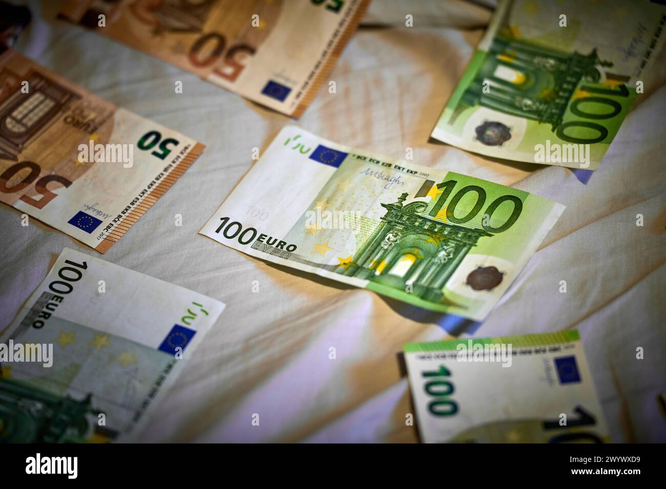 31 March 2024: Symbolic image of counterfeit money, euro cash banknotes scattered on a bed sheet *** Symbolbild Falschgeld, Euro Bargeld Geldscheine liegen auf einem Bettlaken verstreut Stock Photo