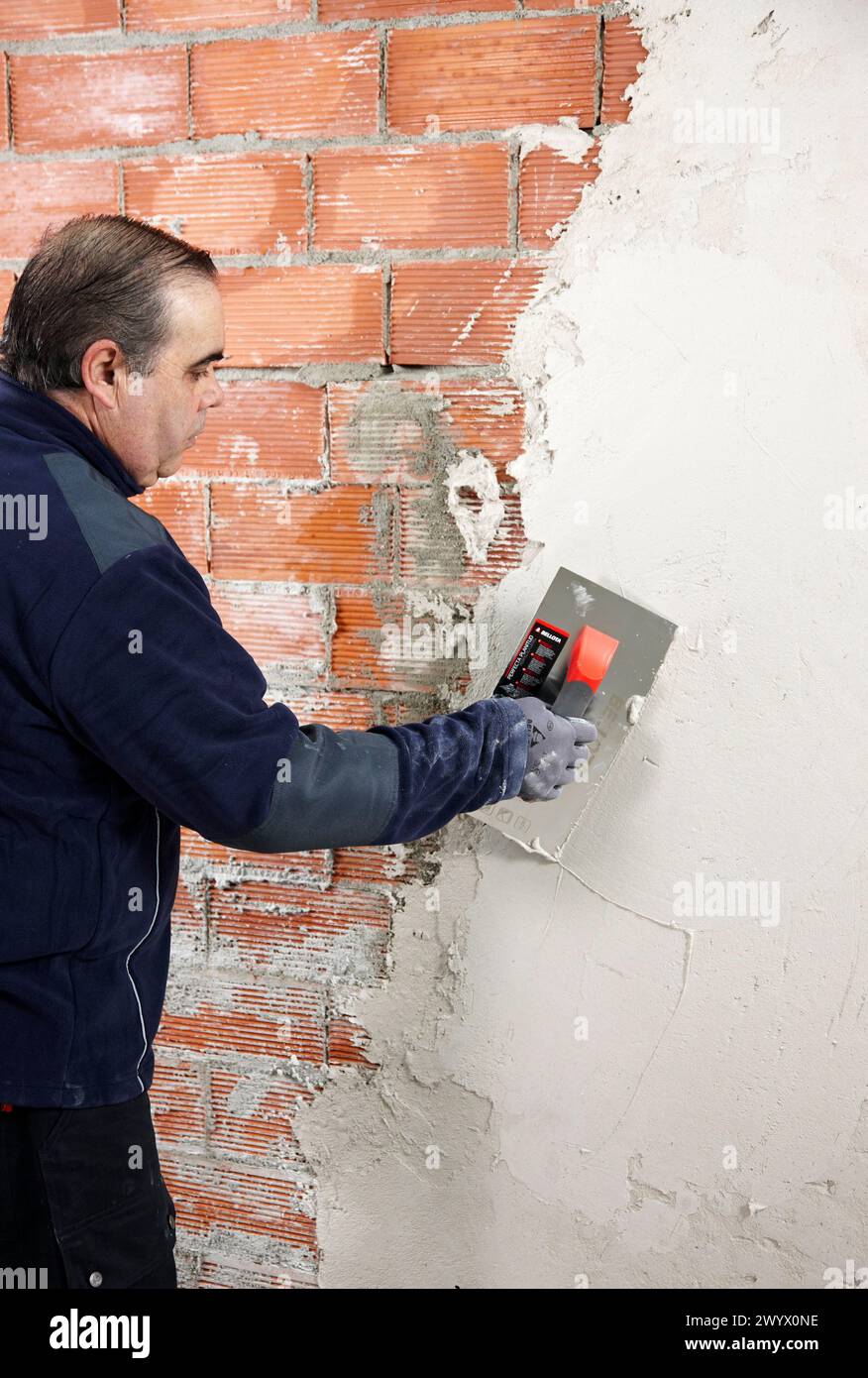 Rendering a brick wall using trowel, new homes under construction, construction site. Stock Photo