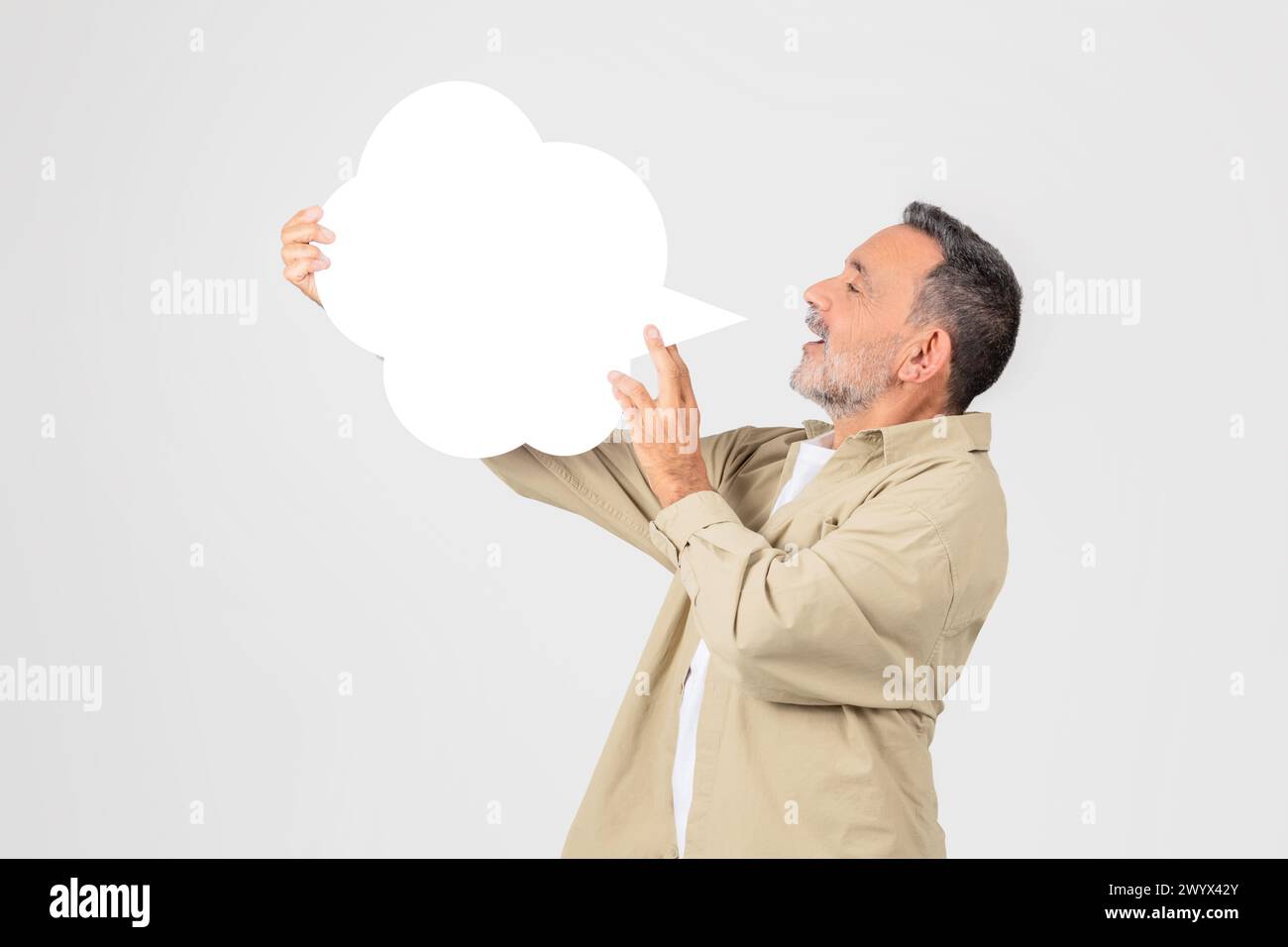 Man holding a blank white speech bubble Stock Photo