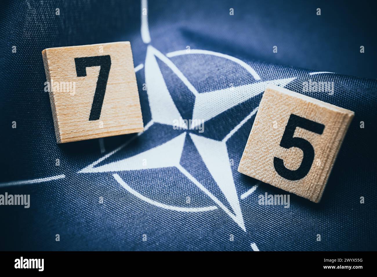NATO Flag With The Number 75, Symbolic Photo Founding Of NATO 75 Years Ago Stock Photo