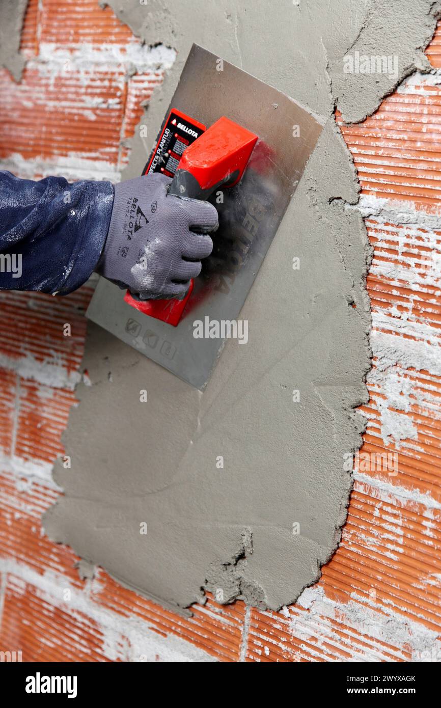 Rendering a brick wall using trowel, new homes under construction, construction site. Stock Photo