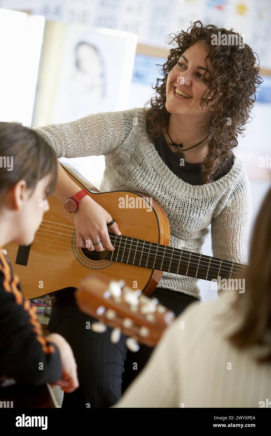 Music teacher, guitar instruction Stock Photo - Alamy