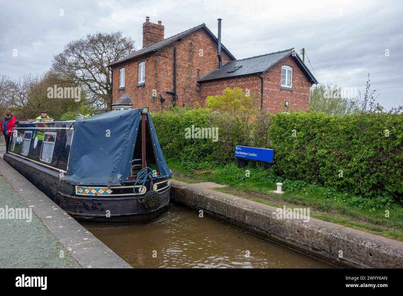 Man on a canal narrowboat passing through Hurleston junction locks on the Llangollen canal before joining the Shropshire union canal Stock Photo