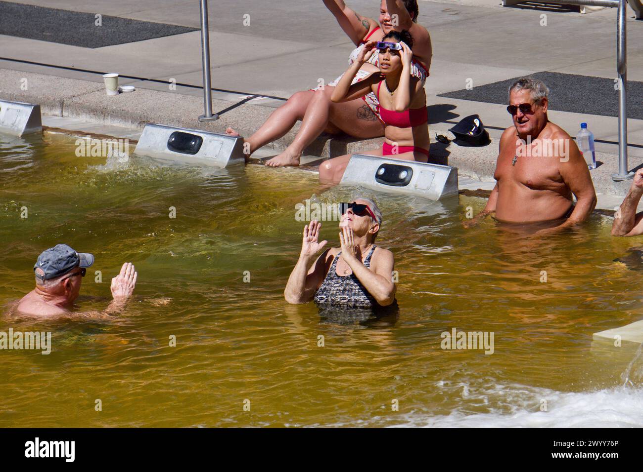 Glenwood Springs, Colorado, USA. 8 April 2024. Bathers in the historic Glenwood Hot Springs Pool, the largest hot springs swimming pool in the world, view the solar eclipse from the Rocky Mountains. Credit: Kristin Cato/Alamy Lives News Stock Photo