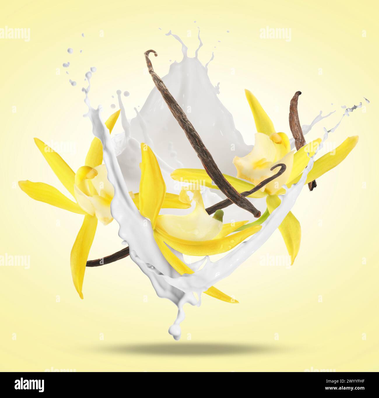 Vanilla pods and flowers with splash of milk in air on pale yellow background Stock Photo