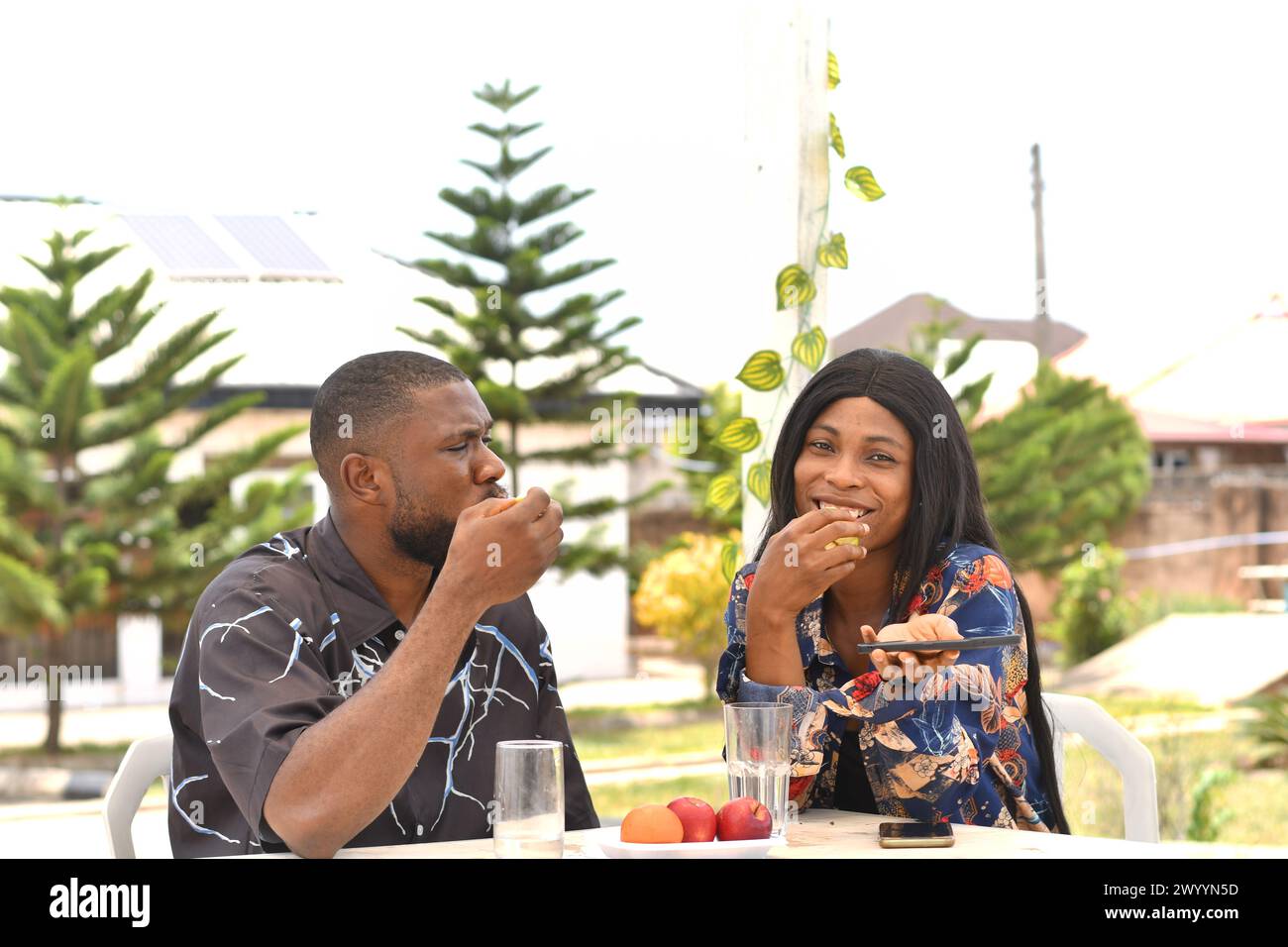 Happy african young couple sitting in cafe Stock Photo - Alamy