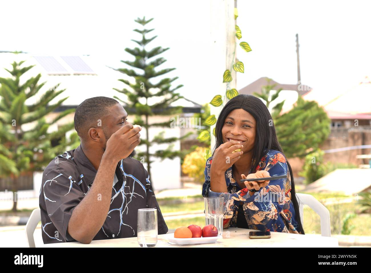 Happy african young couple sitting in cafe Stock Photo - Alamy