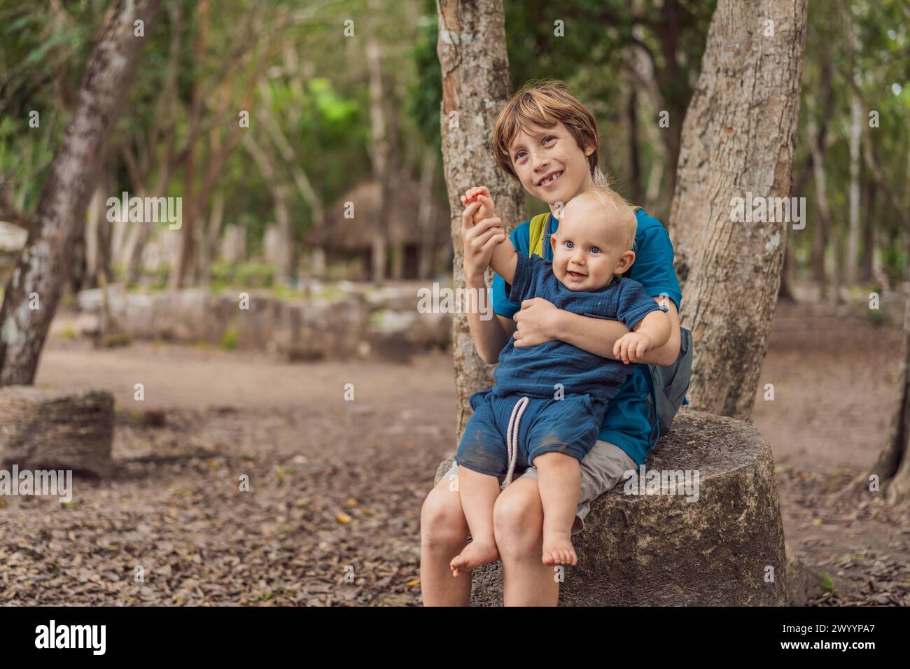 Happy laughing teen boy holding his baby brother Stock Photo - Alamy