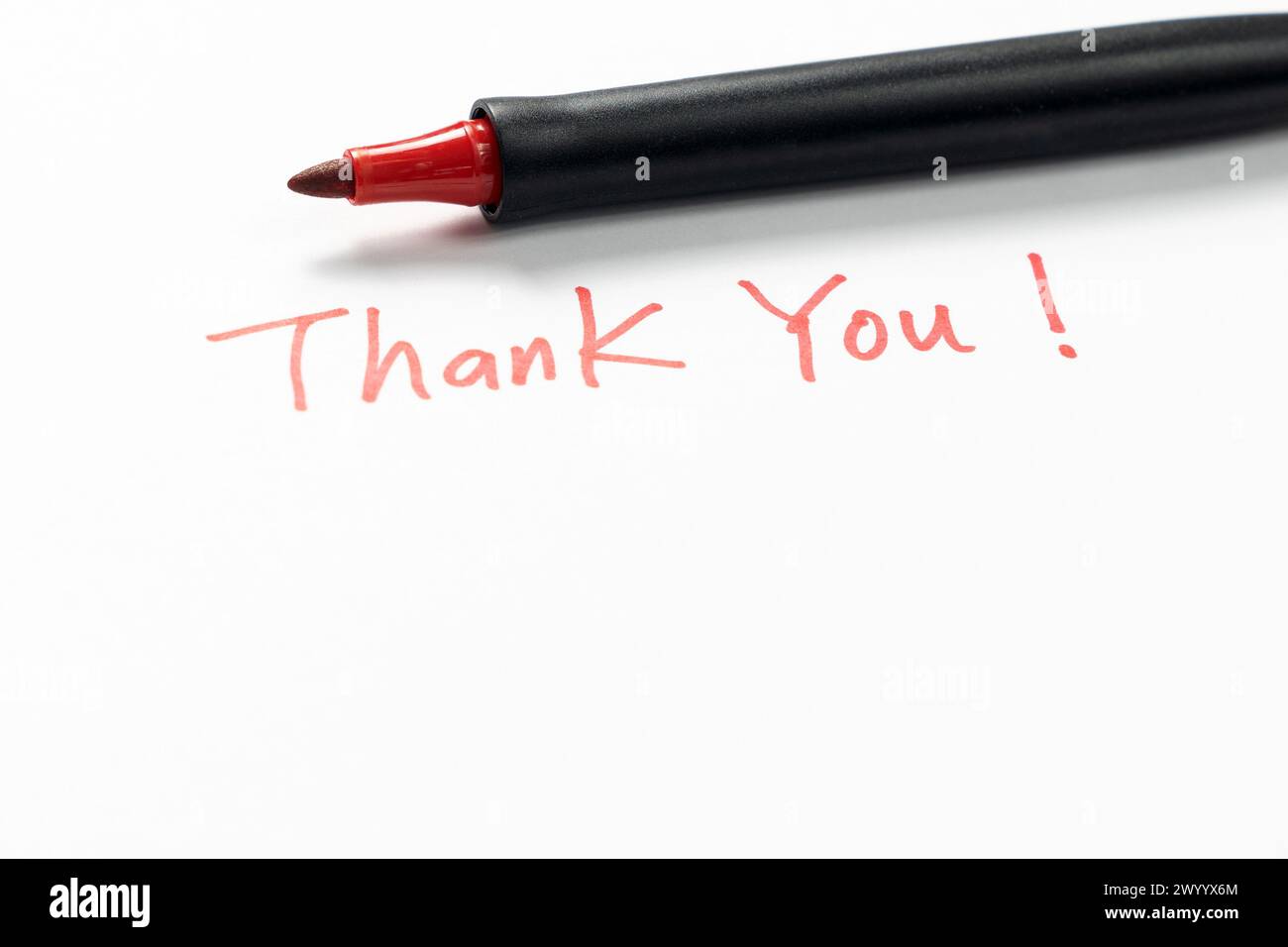 Hand written thank you message with a red pen on white background ...