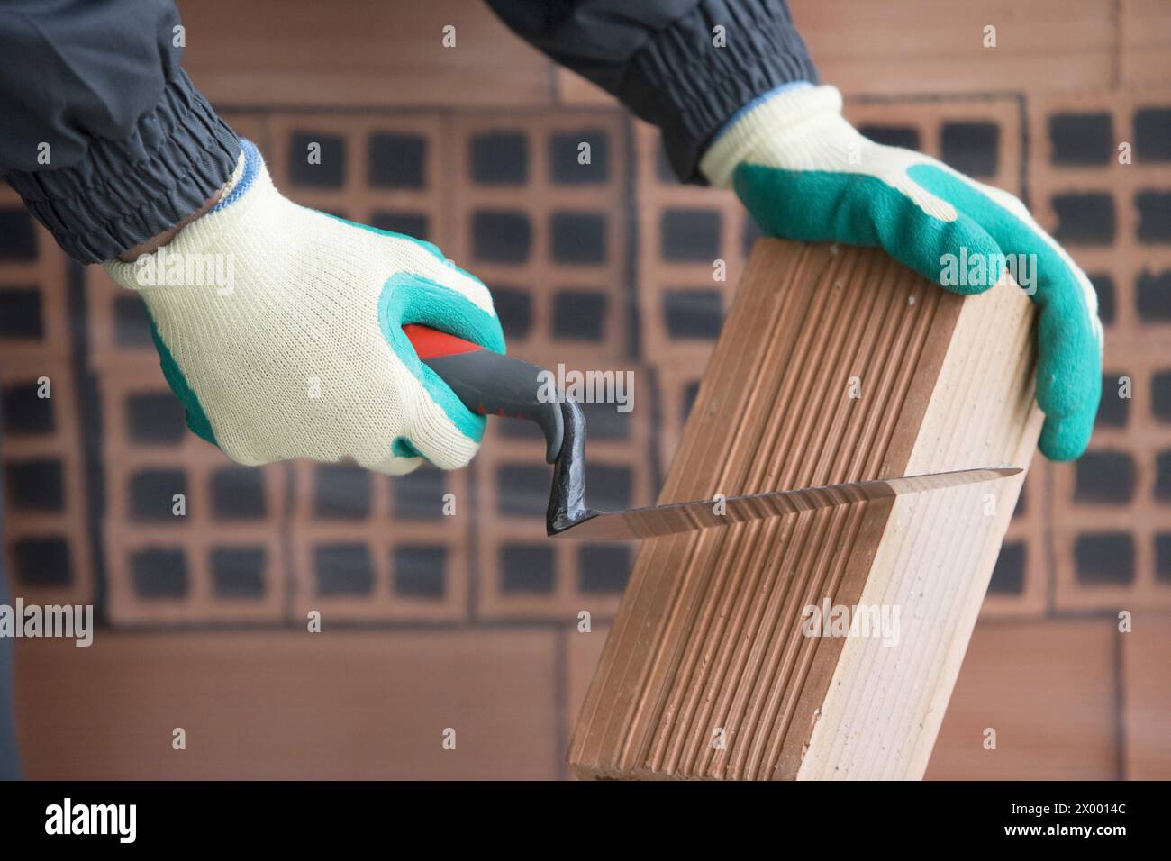 Cutting brick mason with trowel, housing construction. Stock Photo