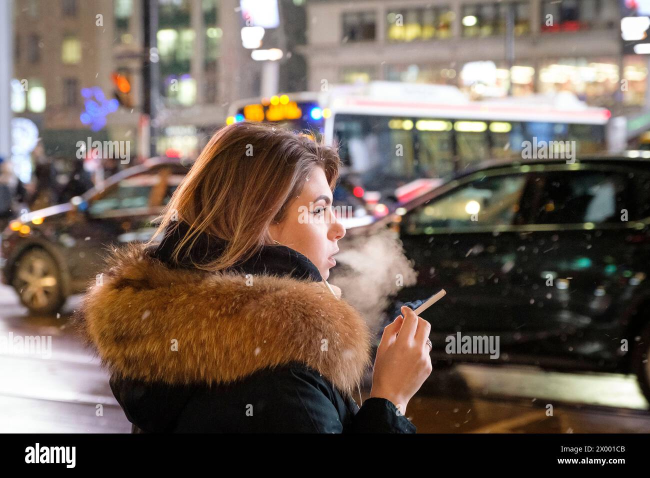 A woman is smoking a cigarette and exhales the smoke. Stock Photo