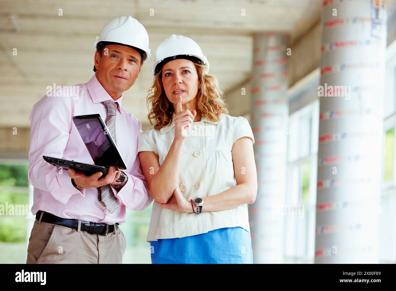 Architect and client with tablet PC in construction site. Stock Photo