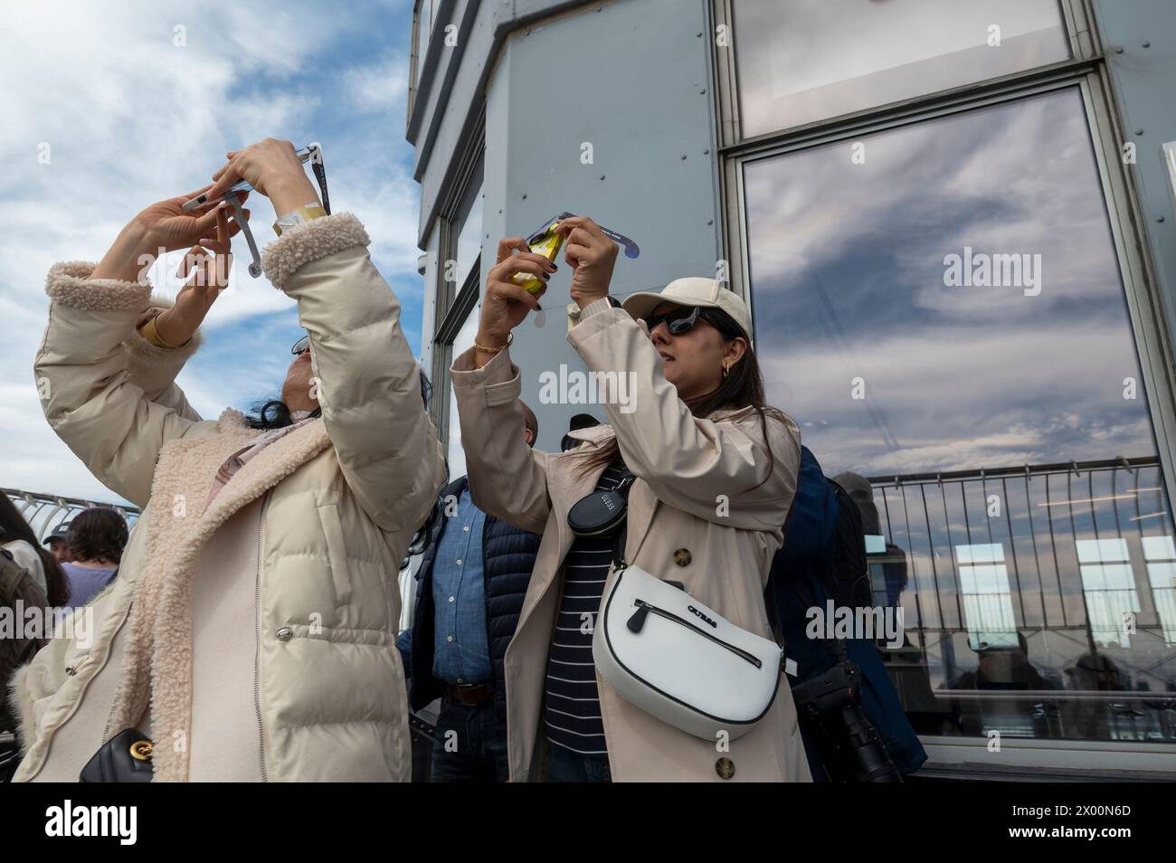 New York, New York, USA. 8th Apr, 2024. (NEW) Solar Eclipse 2024 in New York City. April 08, 2024, New York, New York, USA: People watch a partial solar eclipse from the 86th floor Observation deck of the Empire State Building on April 8, 2024 in New York City. With the first solar eclipse to pass through North America in seven years, New York City was not in the path of totality, with only 90% of the sun covered by the moon; the next eclipse visible in the United States will be in 2044. (Credit: M10s/TheNews2) (Foto: M10s/Thenews2/Zumapress) (Credit Image: © Ron Adar/TheNEWS2 via Stock Photo