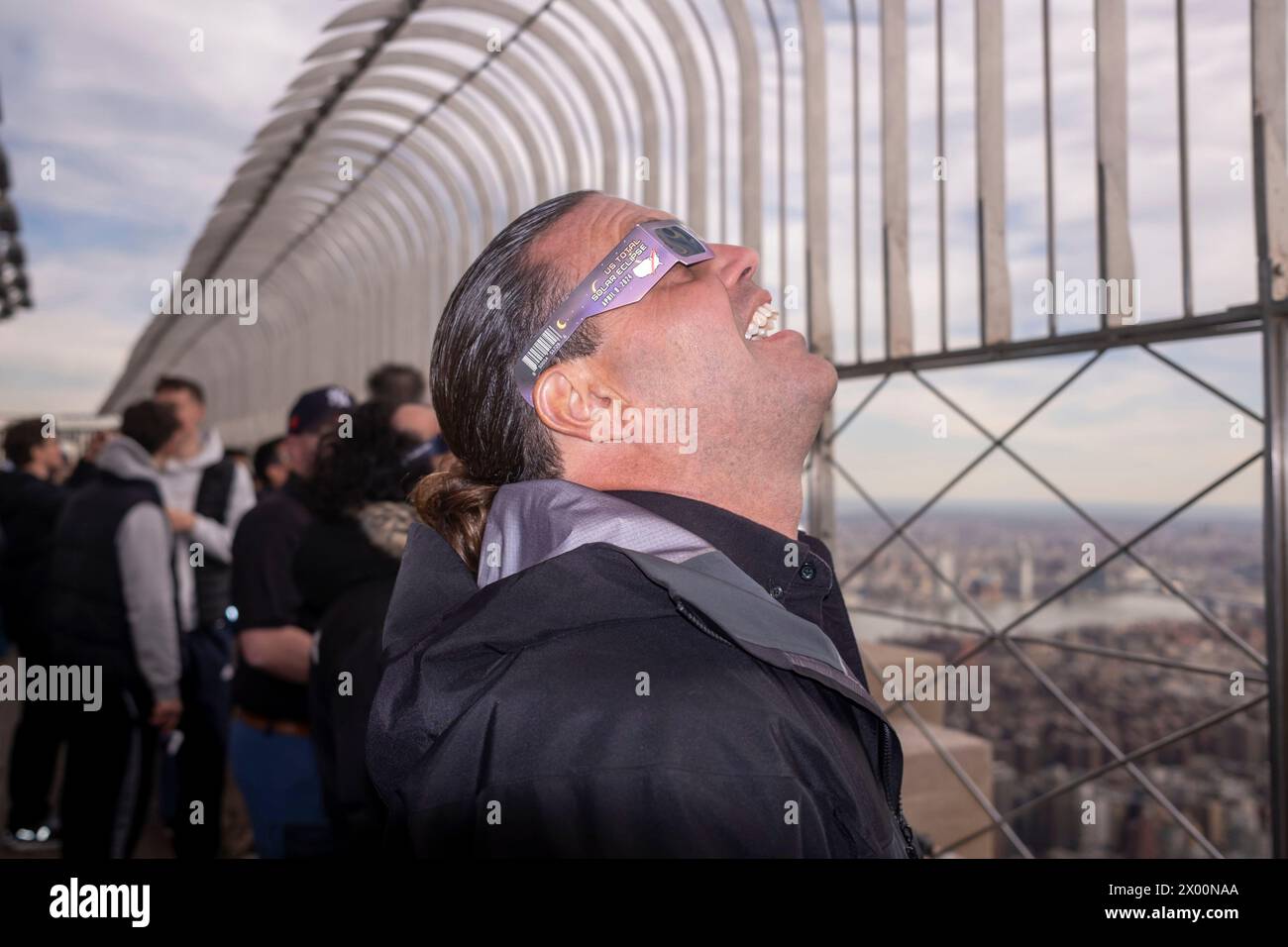 New York, New York, USA. 8th Apr, 2024. (NEW) Solar Eclipse 2024 in New York City. April 08, 2024, New York, New York, USA: A man wearing protective glasses views the partial solar eclipse from the 86th floor Observation deck of the Empire State Building on April 8, 2024 in New York City. With the first solar eclipse to pass through North America in seven years, New York City was not in the path of totality, with only 90% of the sun covered by the moon; the next eclipse visible in the United States will be in 2044. (Credit: M10s/TheNews2) (Foto: M10s/Thenews2/Zumapress) (Credit Ima Stock Photo