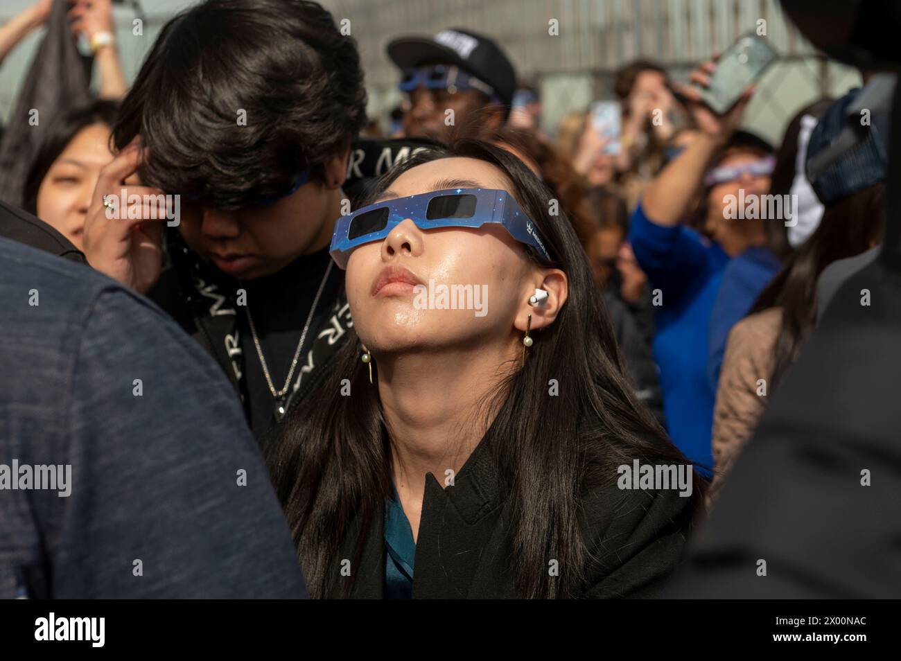 New York, New York, USA. 8th Apr, 2024. (NEW) Solar Eclipse 2024 in New York City. April 08, 2024, New York, New York, USA: A woman wearing protective glasses views the partial solar eclipse from the 86th floor Observation deck of the Empire State Building on April 8, 2024 in New York City. With the first solar eclipse to pass through North America in seven years, New York City was not in the path of totality, with only 90% of the sun covered by the moon; the next eclipse visible in the United States will be in 2044. (Credit: M10s/TheNews2) (Foto: M10s/Thenews2/Zumapress) (Credit I Stock Photo