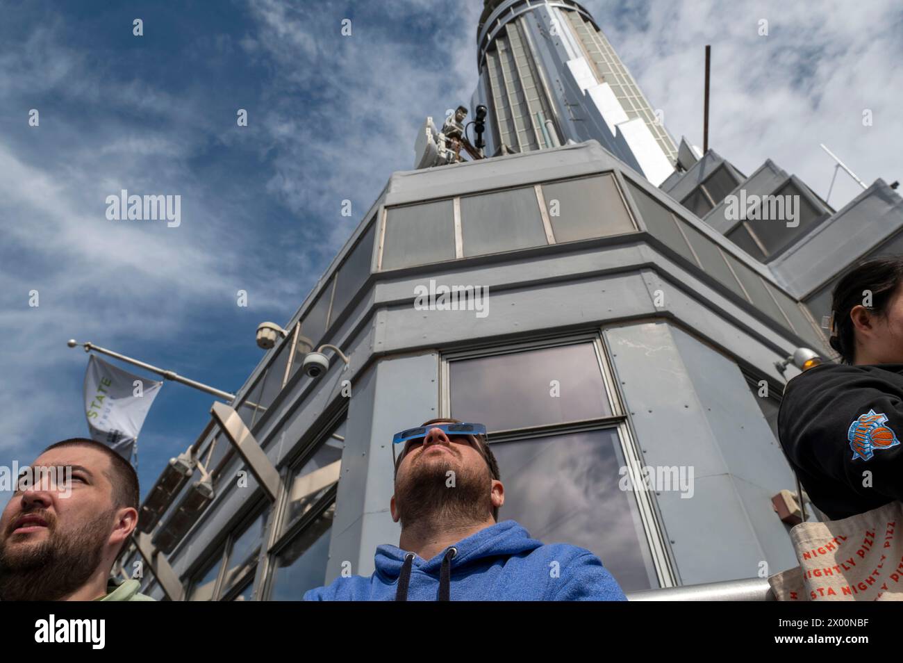 New York, New York, USA. 8th Apr, 2024. (NEW) Solar Eclipse 2024 in New York City. April 08, 2024, New York, New York, USA: People watch a partial solar eclipse from the 86th floor Observation deck of the Empire State Building on April 8, 2024 in New York City. With the first solar eclipse to pass through North America in seven years, New York City was not in the path of totality, with only 90% of the sun covered by the moon; the next eclipse visible in the United States will be in 2044. (Credit: M10s/TheNews2) (Foto: M10s/Thenews2/Zumapress) (Credit Image: © Ron Adar/TheNEWS2 via Stock Photo