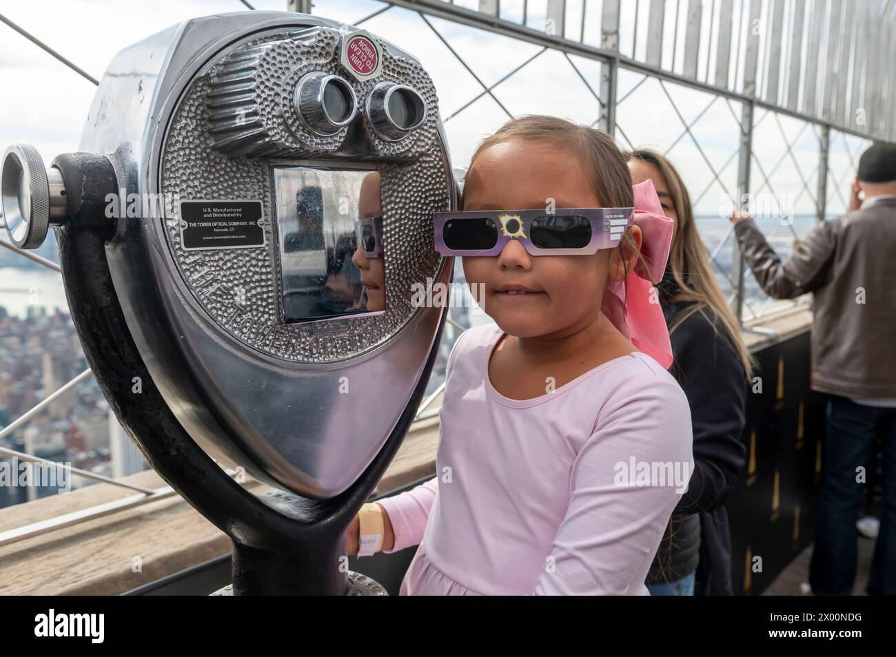 New York, New York, USA. 8th Apr, 2024. (NEW) Solar Eclipse 2024 in New York City. April 08, 2024, New York, New York, USA: Seven year-old Sierra wears a pair of protective glasses to view the partial solar eclipse from the 86th floor Observation deck of the Empire State Building on April 8, 2024 in New York City. With the first solar eclipse to pass through North America in seven years, New York City was not in the path of totality, with only 90% of the sun covered by the moon; the next eclipse visible in the United States will be in 2044. (Credit: M10s/TheNews2) (Foto: M10s/Thene Stock Photo