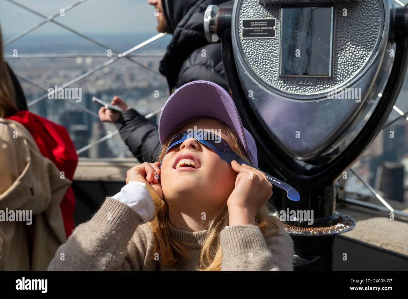 New York, New York, USA. 8th Apr, 2024. (NEW) Solar Eclipse 2024 in New York City. April 08, 2024, New York, New York, USA: Nine year-old Nika wears a pair of protective glasses to view the partial solar eclipse from the 86th floor Observation deck of the Empire State Building on April 8, 2024 in New York City. With the first solar eclipse to pass through North America in seven years, New York City was not in the path of totality, with only 90% of the sun covered by the moon; the next eclipse visible in the United States will be in 2044. (Credit: M10s/TheNews2) (Foto: M10s/Thenews2 Stock Photo