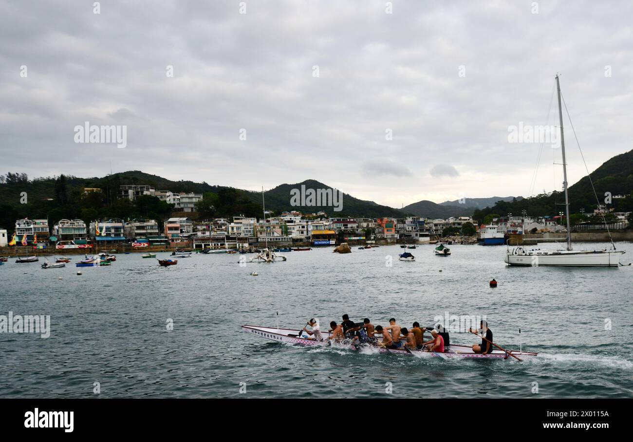 A rowing team practicing by the Yung Shue Wan waterfront, Lamma Island ...