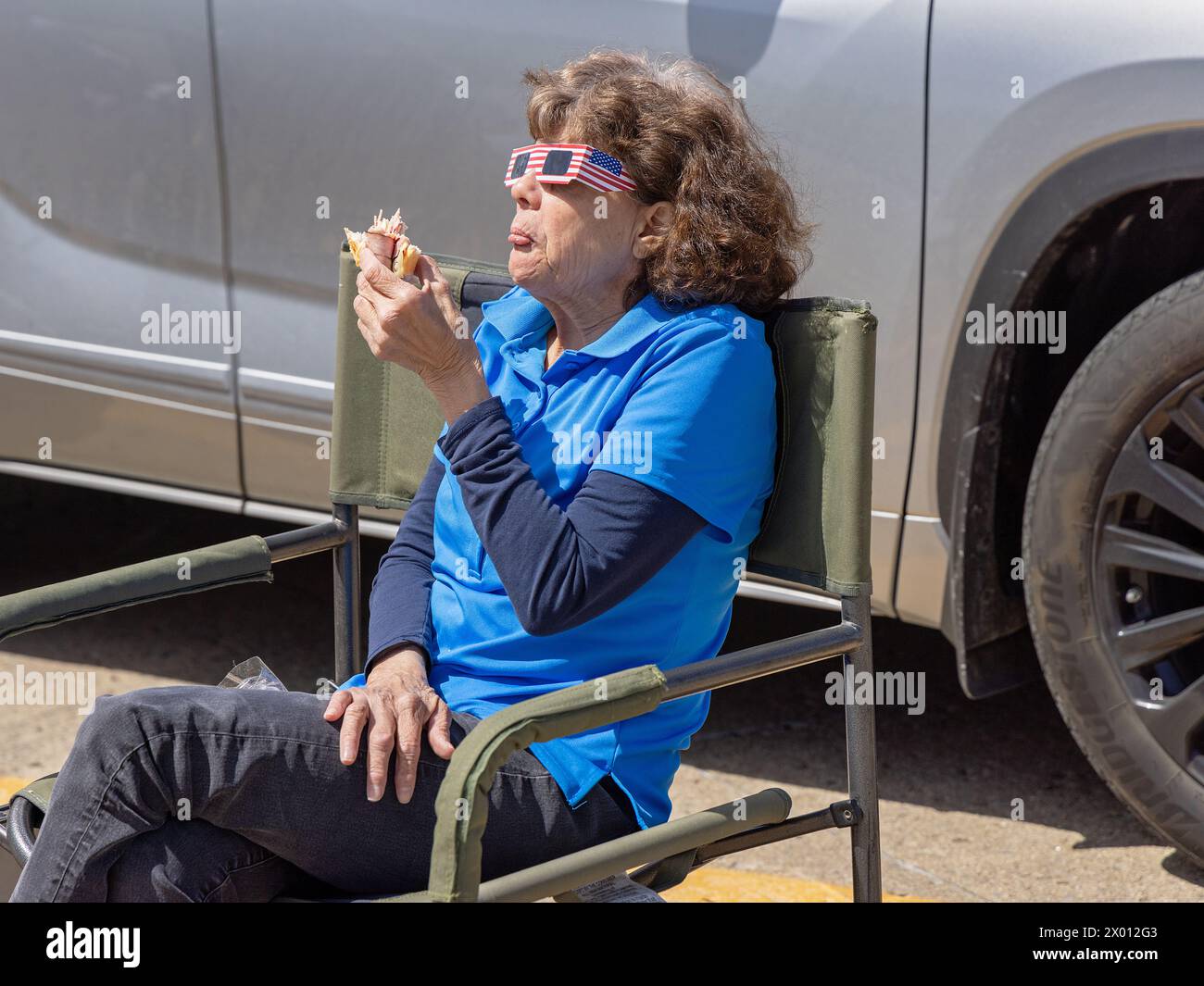 Flora, Illinois, USA. 8th April, 2024. A woman eats a sandwich while