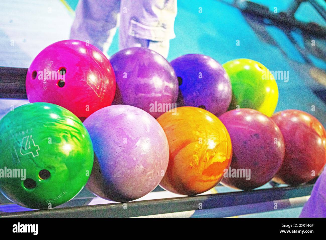 choose multi-colored balls according to their heaviness for the game of bowling. Active holidays with family Stock Photo